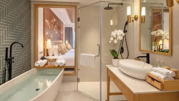 A modern bathroom with a freestanding bathtub, a glass-enclosed shower, and a vanity with a mirror.
