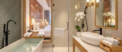 A modern bathroom with a freestanding bathtub, a glass-enclosed shower, and a vanity with a mirror.