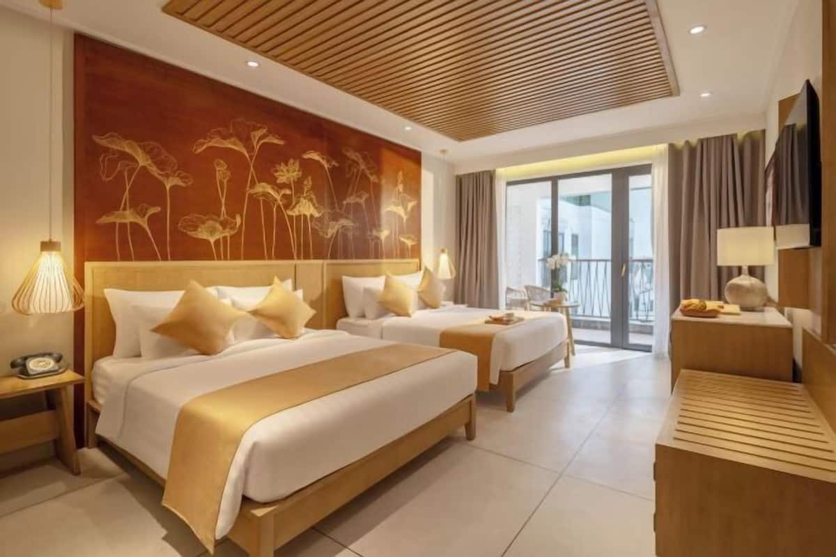 Une chambre d’hôtel avec deux lits, une grande fresque murale, un balcon et une télévision.