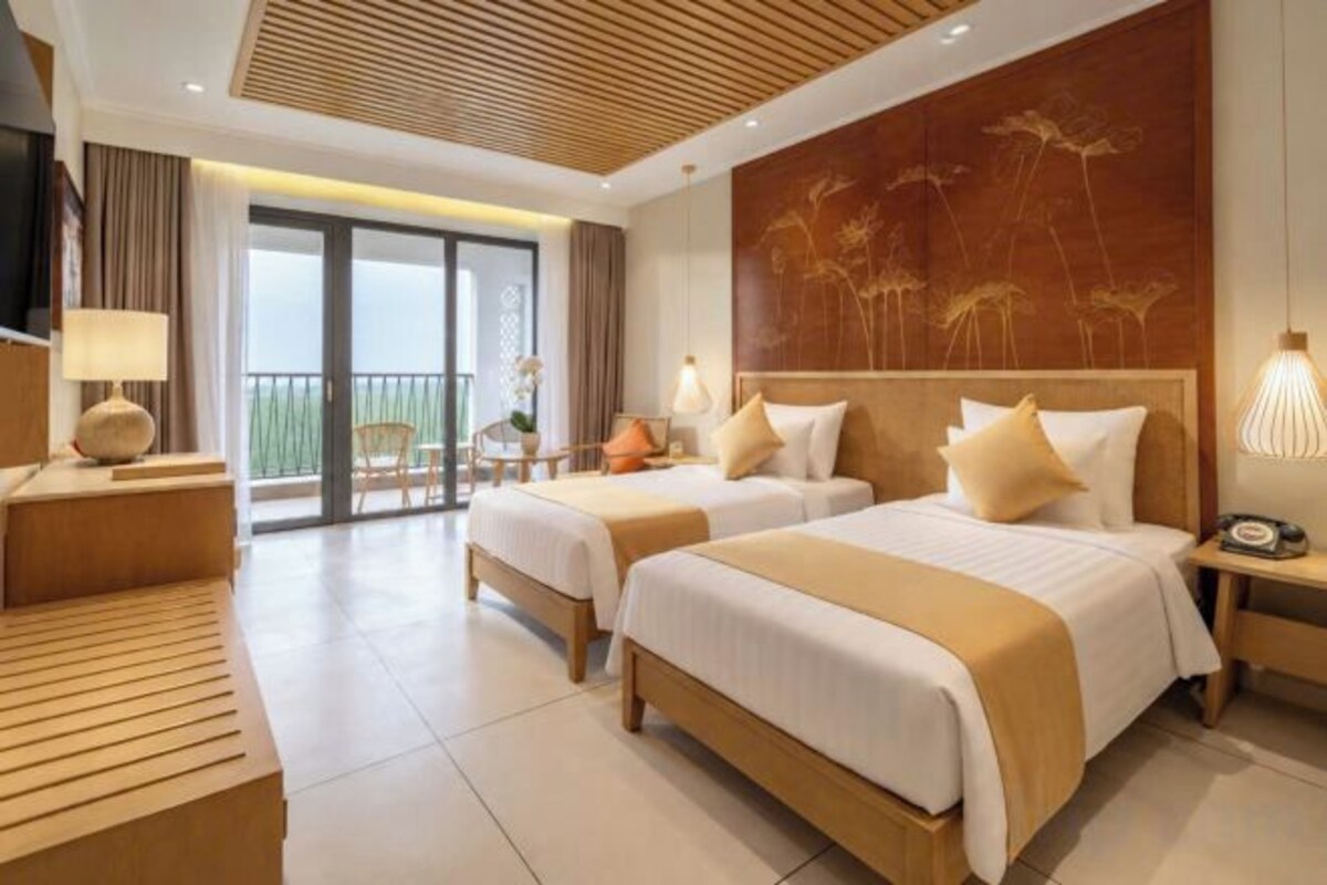 Une chambre d’hôtel avec deux lits, un balcon, une télévision et un plafond en bois.