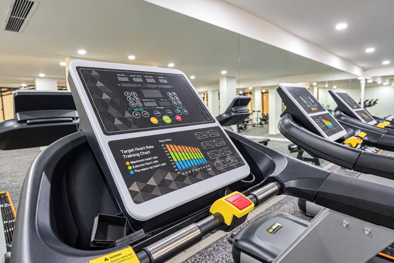 Una cinta de correr con pantalla digital y tabla de entrenamiento de frecuencia cardíaca.