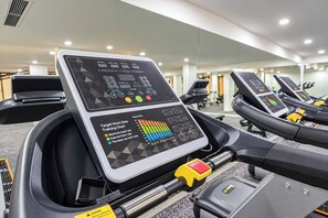 A treadmill with a digital display and a heart rate training chart.