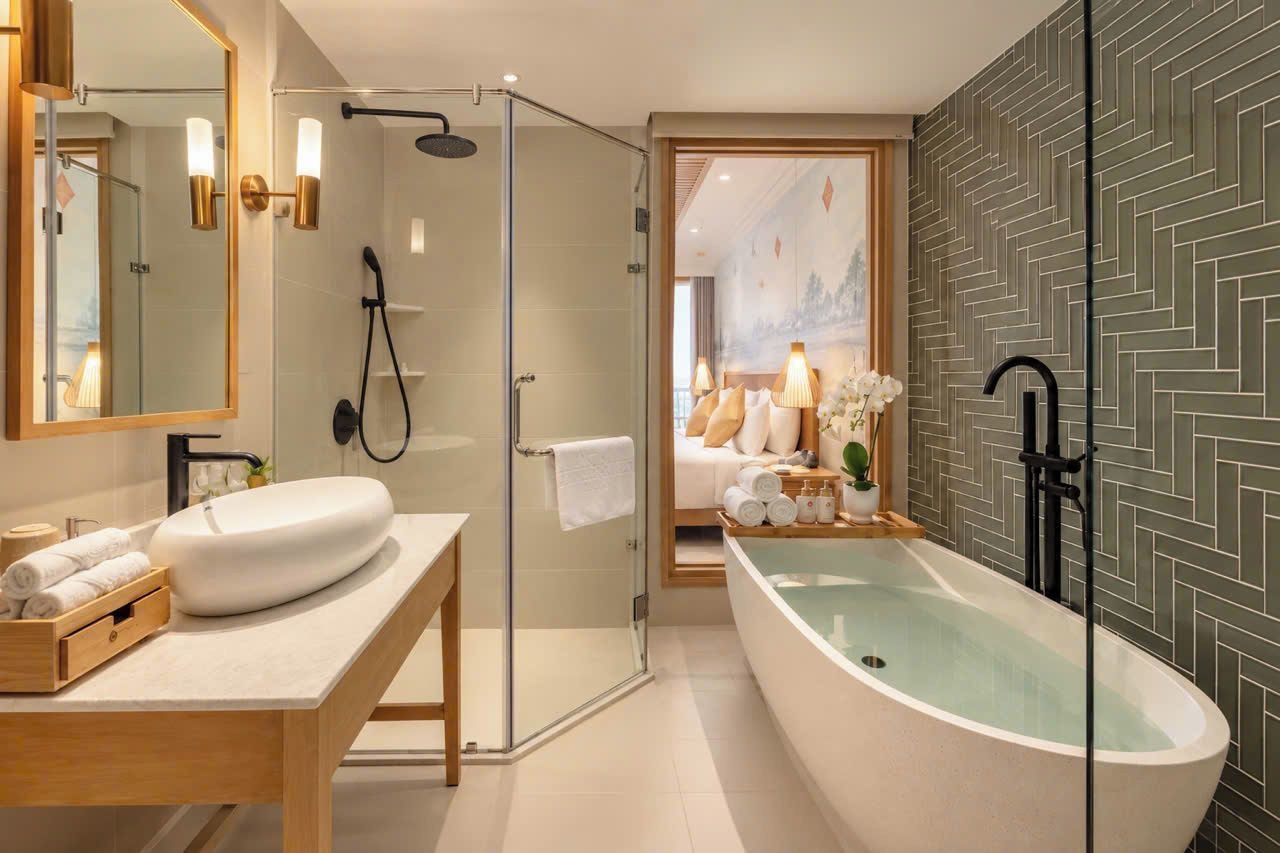 Un baño moderno con una bañera independiente, ducha con cerramiento de vidrio y tocador con un espejo grande.
