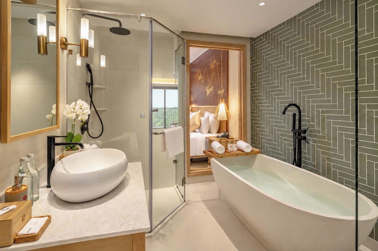 Un baño moderno con una bañera independiente, una ducha con mampara de cristal y un espejo grande.