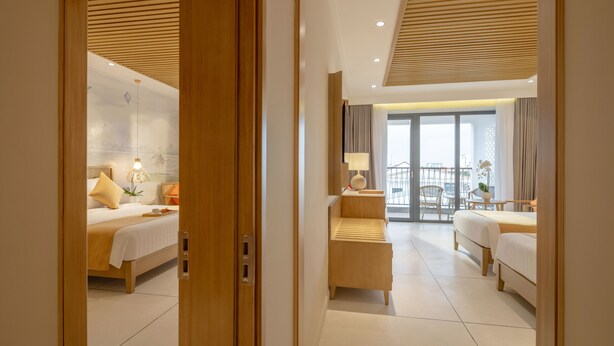 Une chambre d’hôtel avec un lit, une table de chevet, une lampe et une vue sur le balcon.
