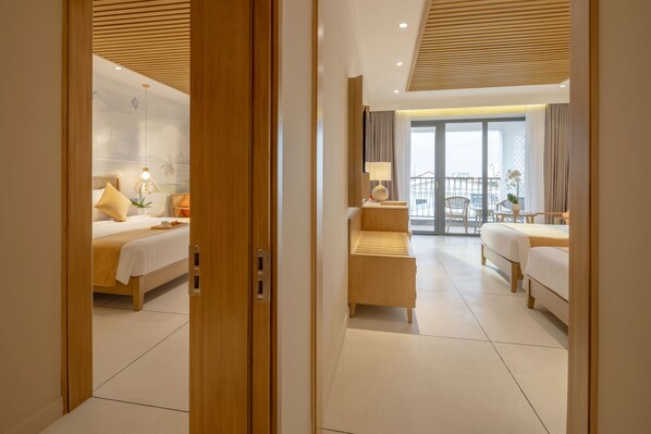 A hotel room with a bed, bedside table, lamp, and a view of the balcony.