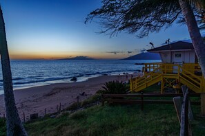 A beach with a lifeguard tower, a wooden staircase, and a clear view of the ocean. - Beautiful Kihei Condo with Ocean & Haleakala Mountain Views (Kihei)