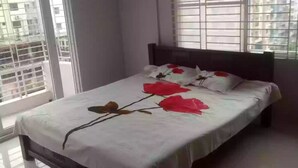 A bedroom with a bed, a ceiling fan, and a window with blinds.