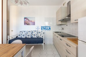 Une cuisine compacte avec un lit, un coin repas et une vue sur la plage.