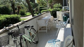 Un'area esterna coperta con tavolo e sedie, una bicicletta e un distributore d'acqua.