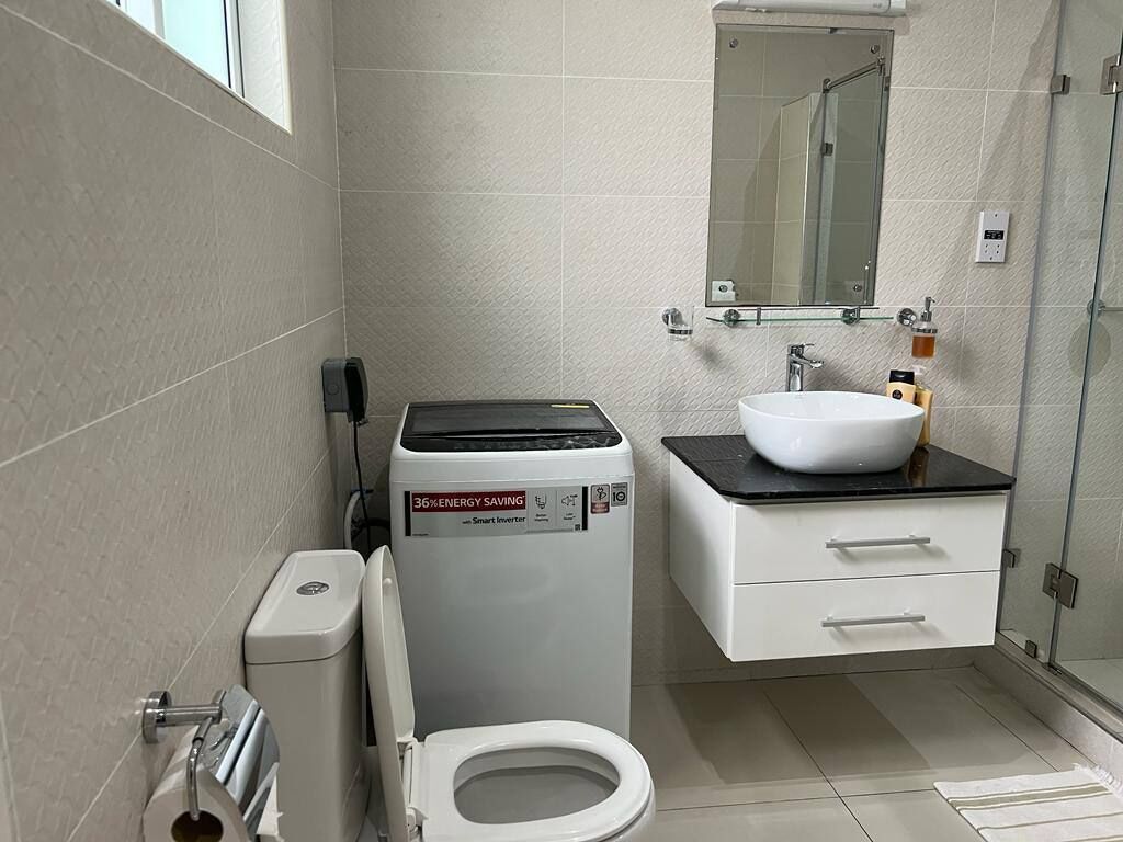A modern bathroom with a toilet, a sink, and a shower.