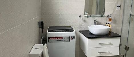 A modern bathroom with a toilet, a sink, and a shower.