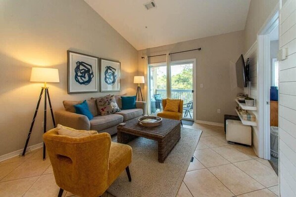 A living room with a sofa, two armchairs, a coffee table, and artwork on the wall.