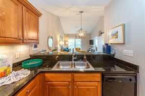 A kitchen with wooden cabinets, a double sink, and a dishwasher. - 2 Adult Bikes! Walk to Pool & Beach! Heart of Seagrove - Summer Breeze at Seagrove Beach 30A (Santa Rosa Beach)