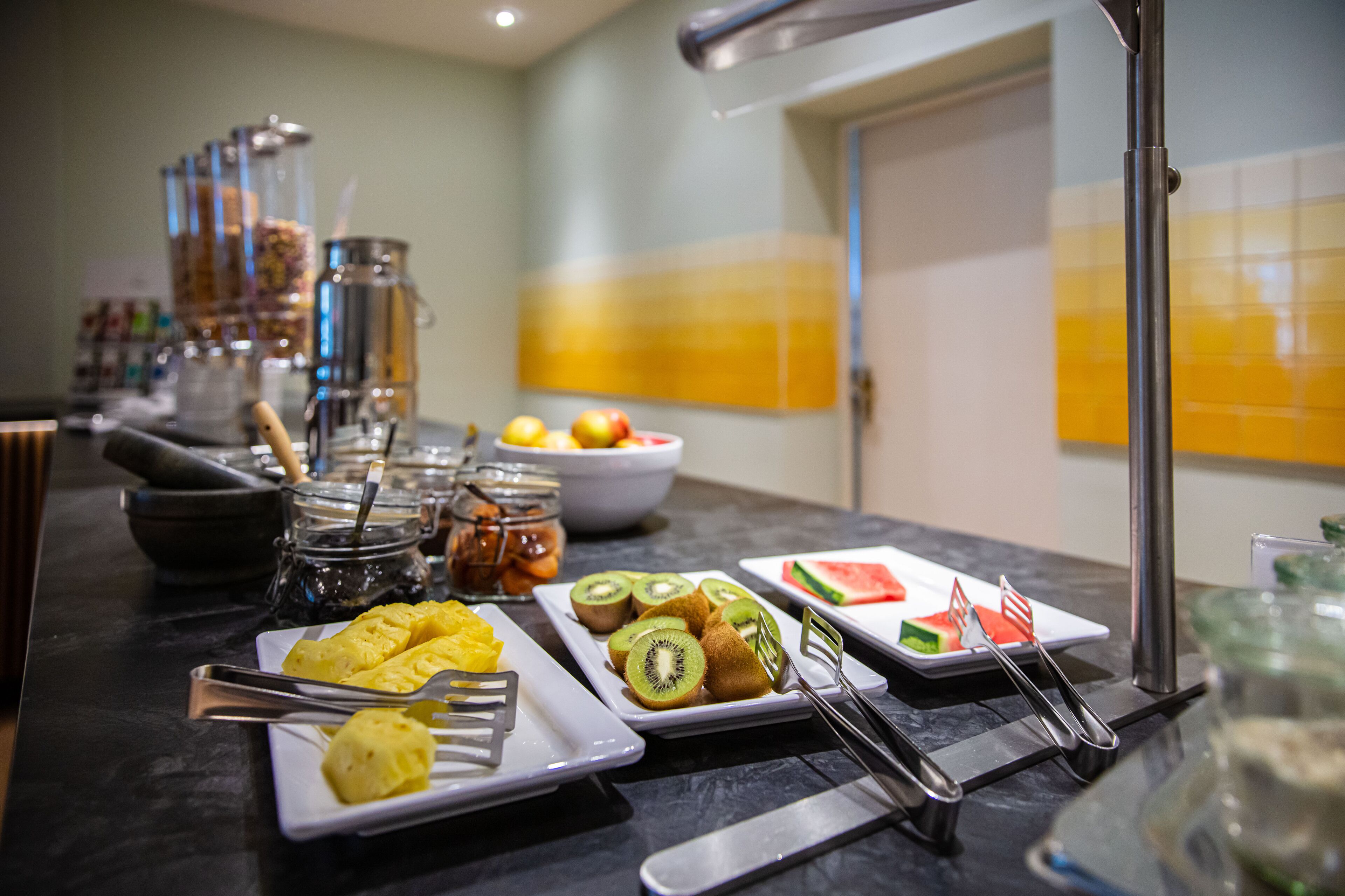 Un buffet con diverse pietanze, tra cui frutta, pasticcini e condimenti.