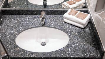 Ein Badezimmer mit zwei Waschbecken, einem Spiegel und Handtüchern.