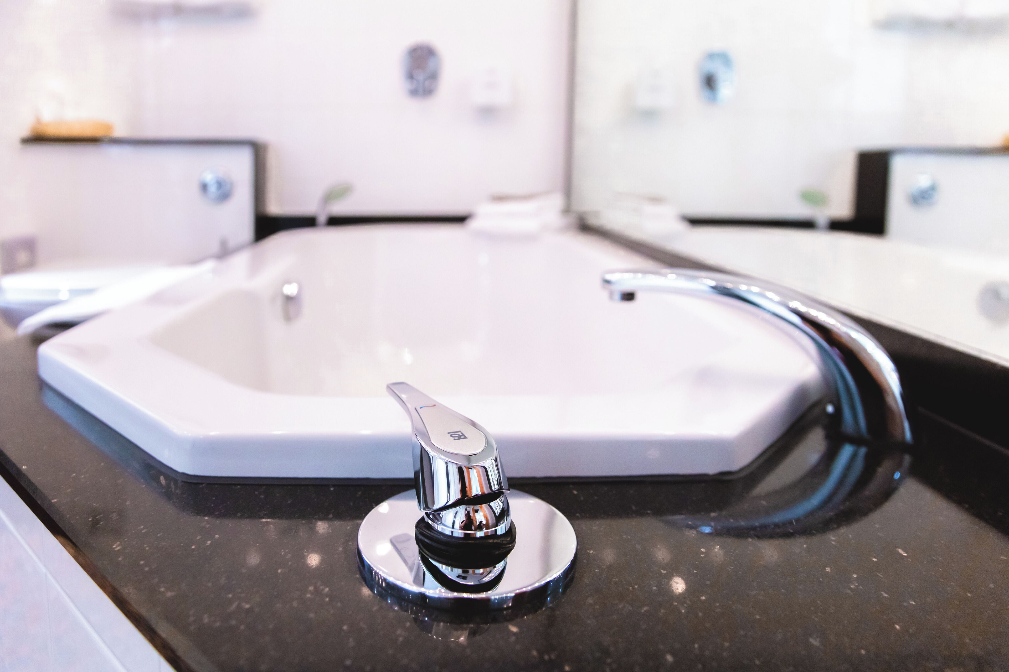 Ein Waschbecken mit Chromarmatur und Seifenspender.