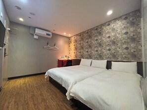 A hotel room with a bed, a desk, and a wall-mounted air conditioner. - Funny Ximen Hotel (Taipei)