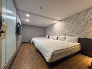 A hotel room with a large bed, a television mounted on the wall, and a patterned wallpaper. - Funny Ximen Hotel (Taipei)