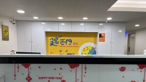 A reception desk with a 'Happy New Year' sign and a 'Funny Ximen Hotel' banner. - Funny Ximen Hotel (Taipei)