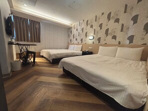 A hotel room with two beds, a desk, and a wall with a patterned design. - Funny Ximen Hotel (Taipei)