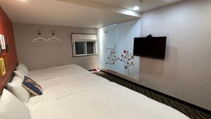 A hotel room with two beds, a flat-screen TV mounted on the wall, and a window with a view of the outside. - Funny Ximen Hotel (Taipei)