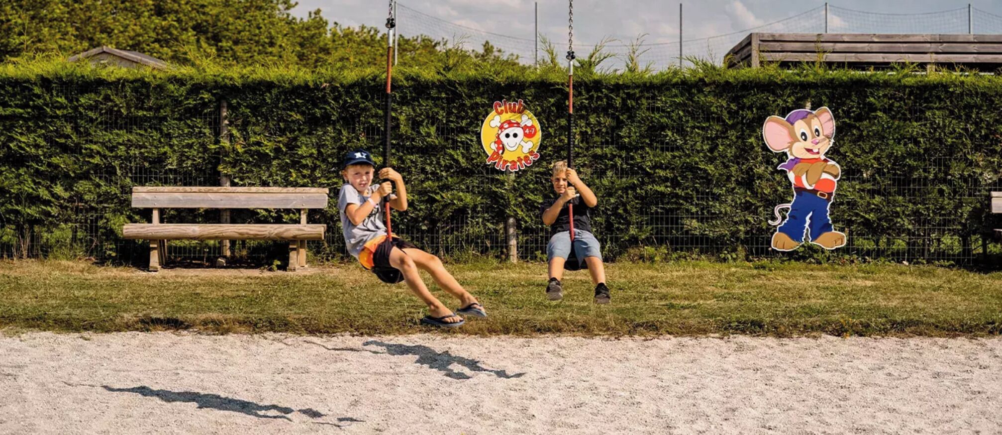 A playground with a swing set and a cartoon character decoration.