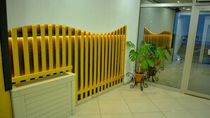 A reception area with a yellow and white color scheme, a potted plant, and a radiator. - Elite Holiday Hotel (Trabzon)