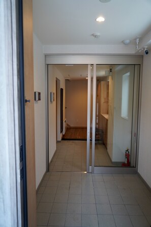 Corridors lead to rooms with glass doors and wooden floors.