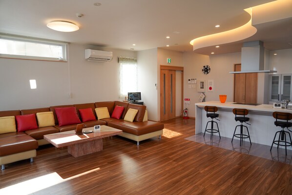 Relax in this stylish living space with a comfortable sofa, coffee table, and kitchen area.