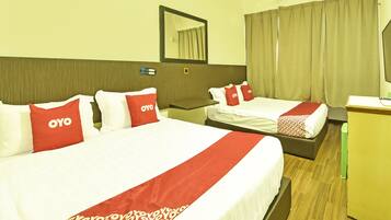 A hotel room with two beds, each with red and white bedding, a wooden headboard, a desk, and a mirror.