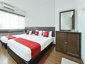 Una habitación de hotel con una cama grande, dos mesitas de noche, un armario y una ventana con persianas.