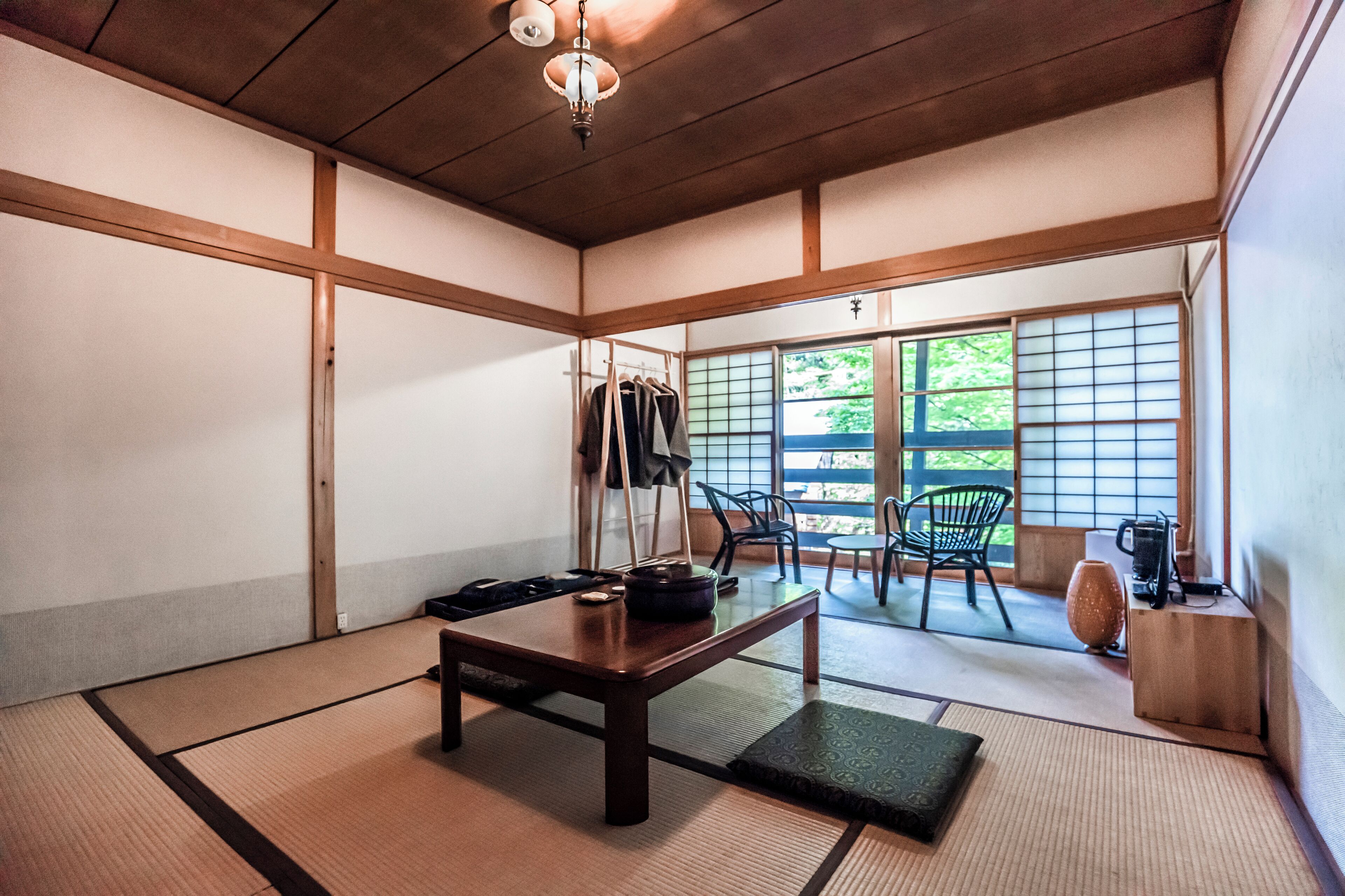 A traditional Japanese room with tatami flooring, a low wooden table, and sliding doors.