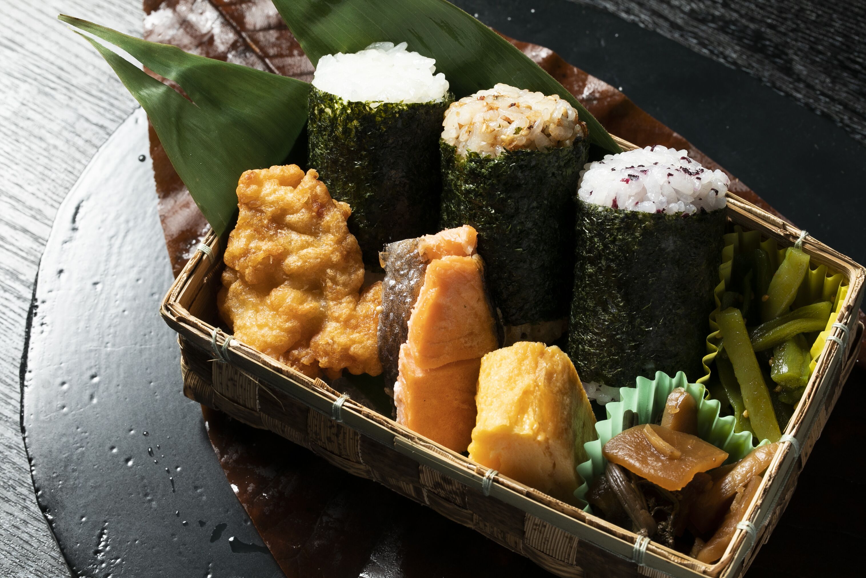 Una tradizionale scatola bento giapponese con sushi, riso, verdure sottaceto e diversi altri elementi.