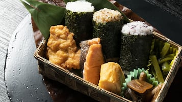 Una tradizionale scatola bento giapponese con sushi, riso, verdure sottaceto e diversi altri elementi.