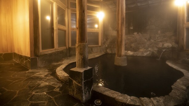 Ein Thermalbereich mit Steinböden, Holzbalken und Steinwänden.