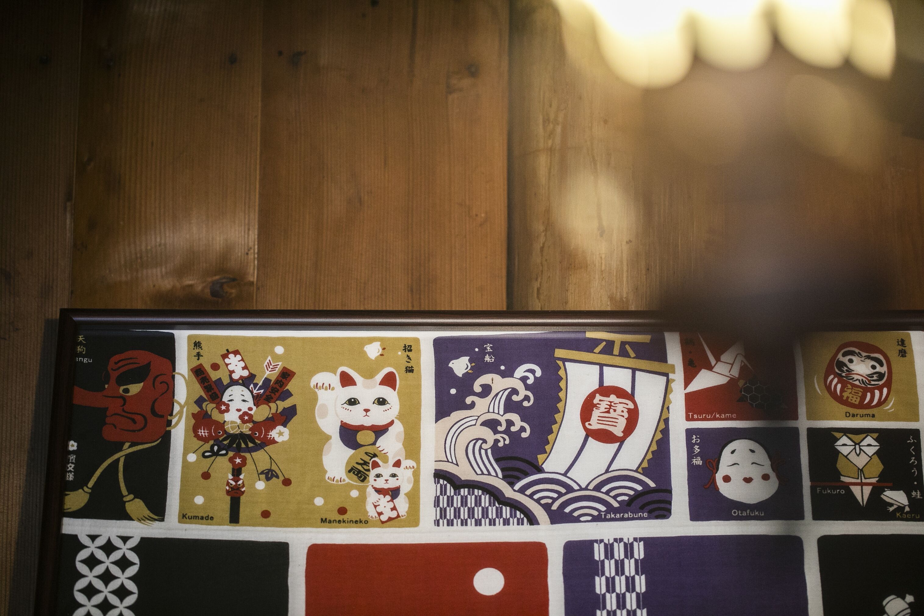 A wooden surface with a framed collection of Japanese artwork.