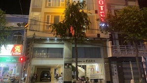 Un edificio de varios pisos con un llamativo letrero que dice 'FARA HOTEL'.