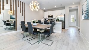 A modern kitchen with white cabinets, stainless steel appliances, and a central island.