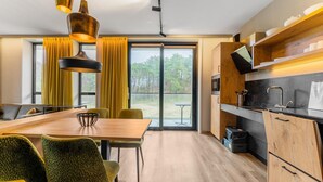 Una cocina moderna con comedor, ventanas amplias y vistas al exterior.