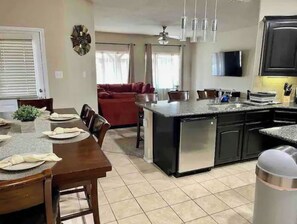 Enjoy meals in the kitchen with a central island and dining table, featuring an oven and stainless steel appliances.