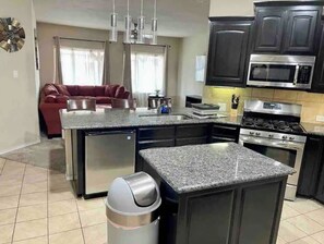 Enjoy cooking in this well-equipped kitchen with a central island, sink, and stove.