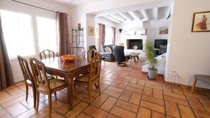 A spacious living area with a dining table and chairs, a sofa, a fireplace, and a potted plant. - Vacation rental house with pool MOULES LS3-424 (Arles)