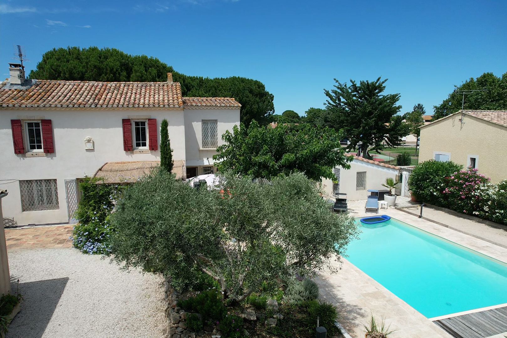 Une villa dotée d’une piscine, entourée de verdure et présentant une architecture traditionnelle.