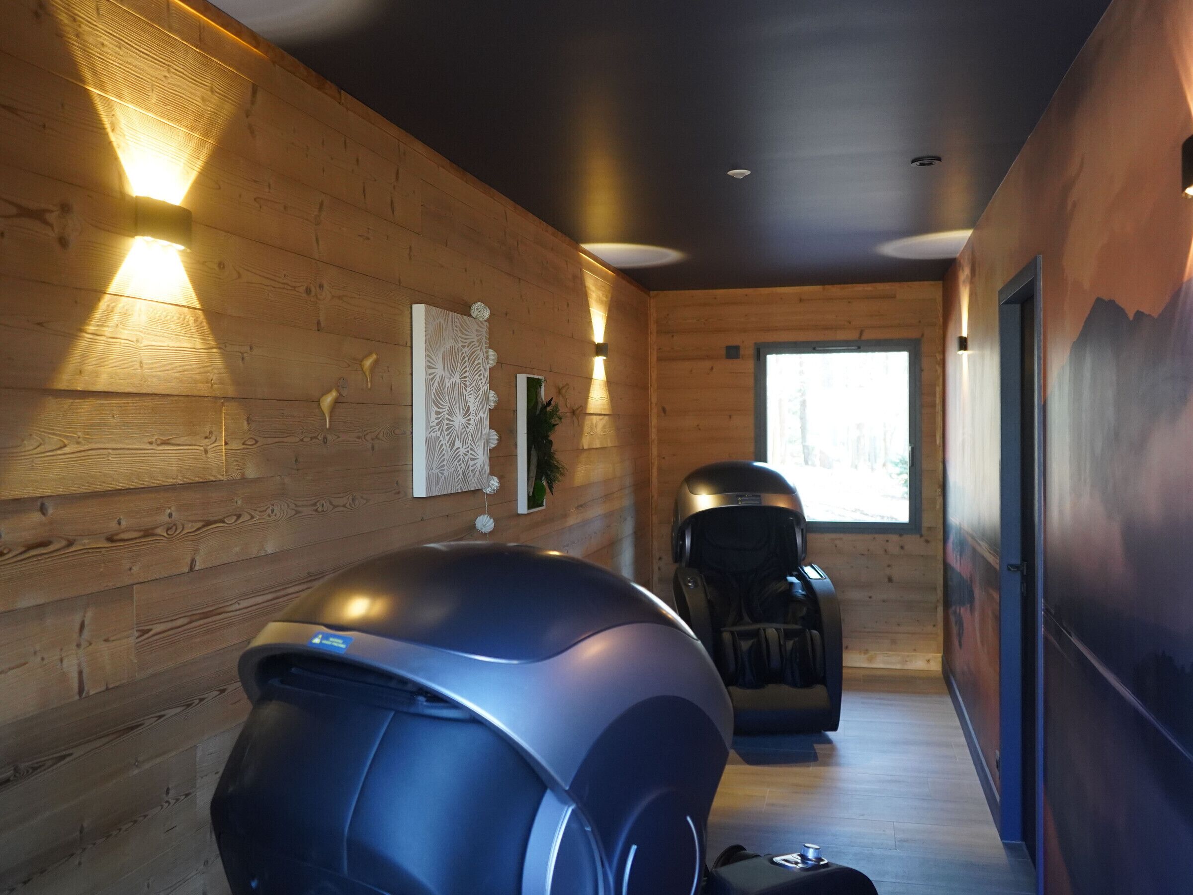 Een sauna met houten wanden, een massagestoel en een stoomdouche.