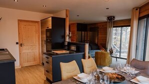 A modern kitchen with a central island, wooden cabinets, and a dining area set for a meal.