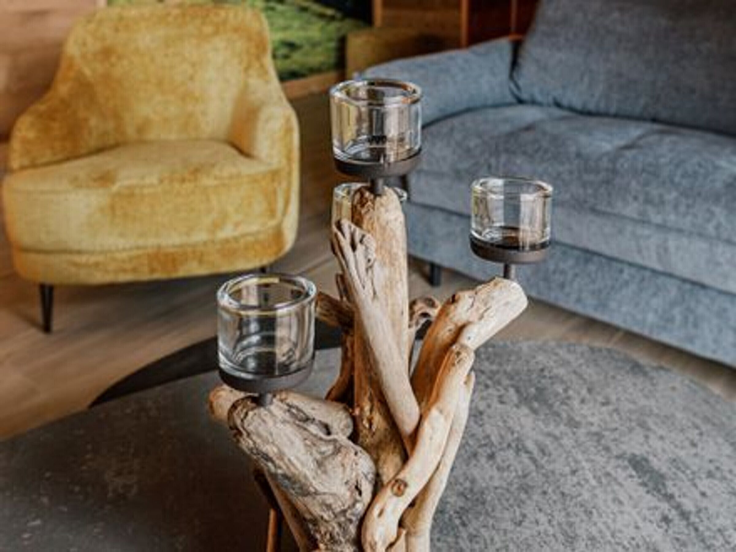 A wooden sculpture with three glass candle holders.