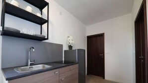 A modern kitchen with a built-in sink, dark wood cabinets, and a black countertop.