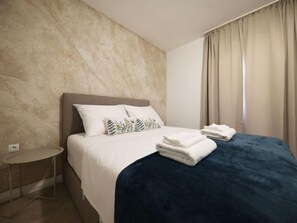 Une chambre d’hôtel avec un lit, une petite table ronde et une table de chevet.
