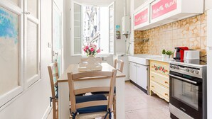 A kitchen with a dining table, chairs, a stove, and cabinets. - Apartment Hérold by Interhome (Nice)